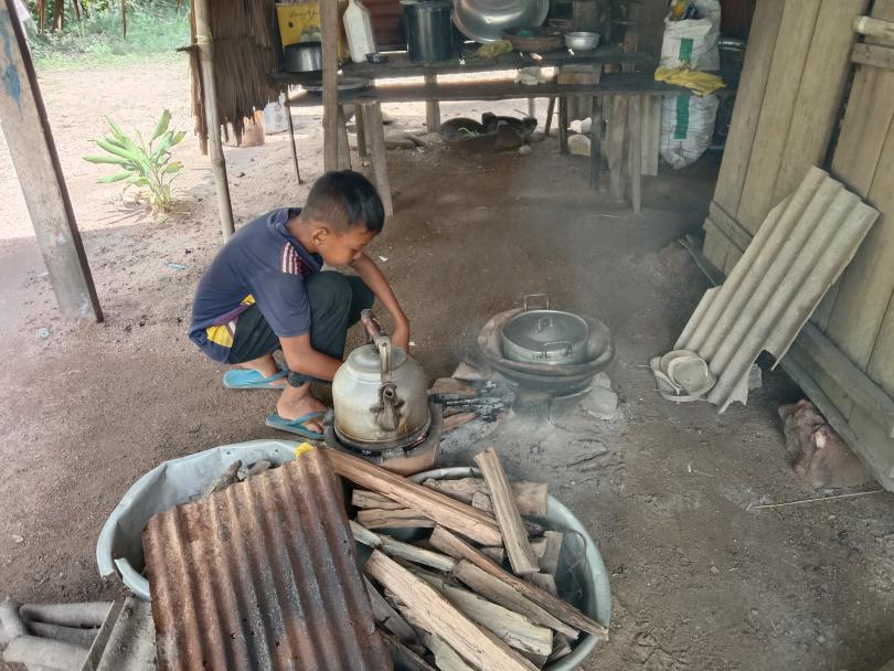 Sochen cooking rice at his home