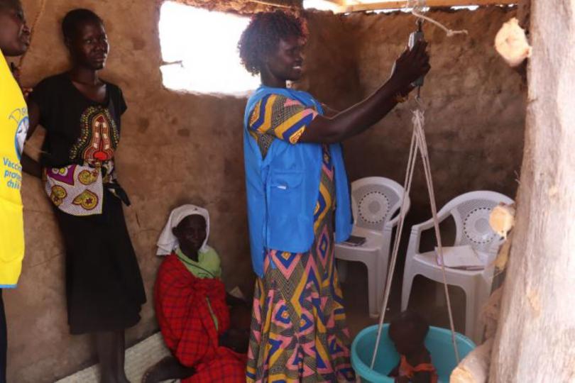 Beatrice Lokwawi, a community health volunteer checks the weight of Ms Lydia Ekeno's baby. Looking on is Nurse Lucy Lomechu. Florence Dzame/Save the Children