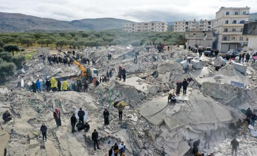 6 Şubat 2022 tarihinde Türkiye sınırında Idlib ilinin kuzeybatısındaki Harim kasabası yakınlarındaki Besnia köyünde bir depremin ardından çökmüş binaların kalıntılarında hayat arayanları ve hayatta kalanları gösteriyor
