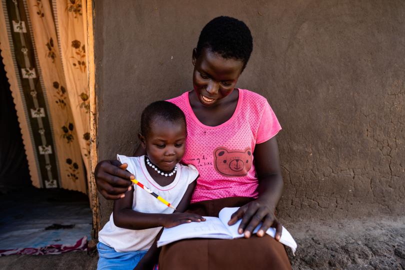 Harriet showing her young sister her homework. Louis Leeson / Save the Children