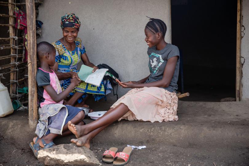 Helen and younger sister Rita with foster mother Prudence. Esther Mbabazi / Save the Children