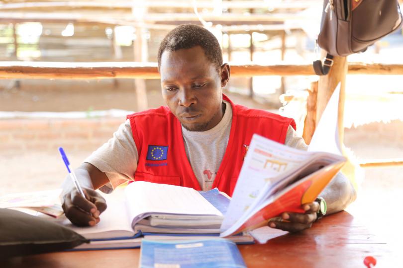 Teacher David Elias marking books. Alun McDonald / Save the Children