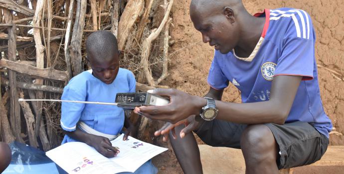 Anna being supported by her brother. Peter Moru / Save the Children