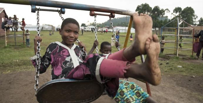 Child playing on swing at a refugee settlement in western Uganda