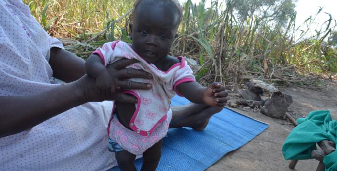 Anna*'s healthy baby with her grandmother. She's looking forward to a happier future