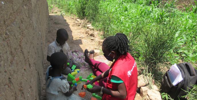 As part of the response to the COVID-19 outbreak in Uganda, which resulted into closure of schools and Child Friendly Spaces, Save the Children closure through home based psychosocial support to children to reduce stress. On a daily basis, Save the Children staff in Rwamwanja refugee settlement visit homes to play with these children and distribute play materials such as blocks. Here Seven-year-old Jack and his sister Five-year-old Uwineza play with a Save the Children staff. More than 2,000 children have b