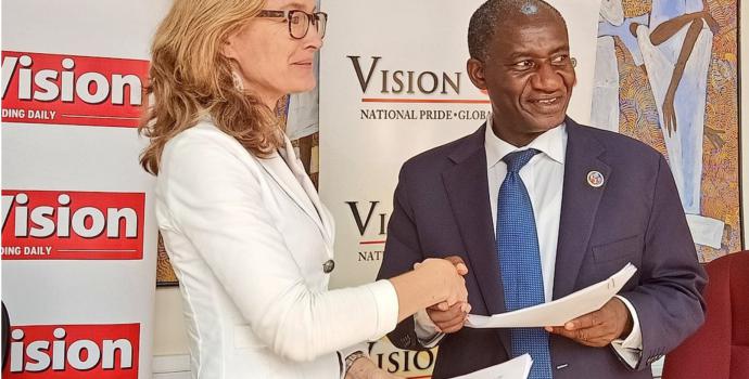 Save the Children's Brechtje van Lith and Vision Group’s Acting Managing Director Gervase Ndyanabo sign the agreement. Photo: New Vision