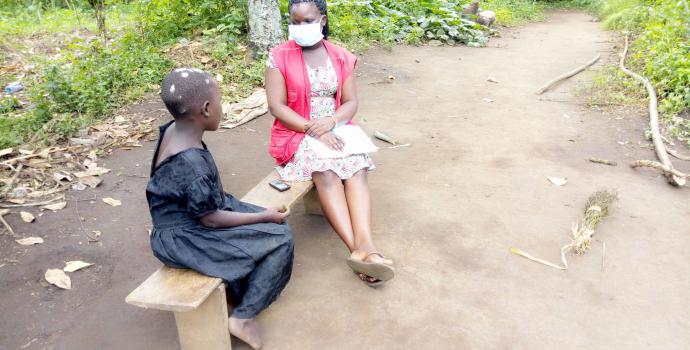 Susan* meets with Save the Children programme officer Sandra Tiino at her home. Eric Monday / Save the Children