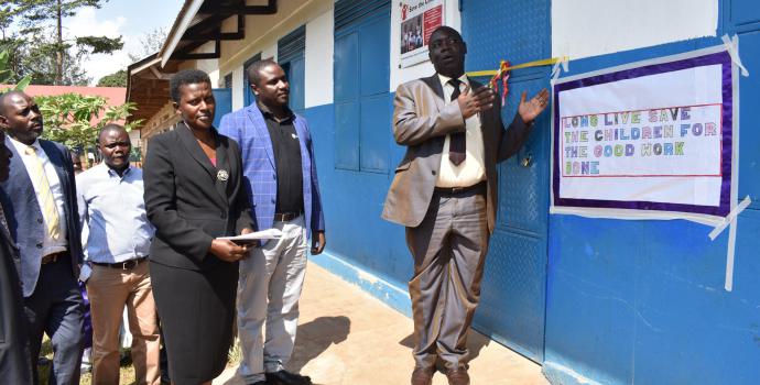 DEO Frederick Kiyingi cuts the ribbon on the new block, with headmistress Susan Nabalagala and Save the Children's Emmanuel Kisangala