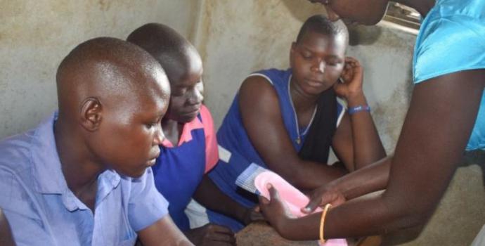 Demonstrating how to use the reusable pads distributed by Patricia and the youth advocates