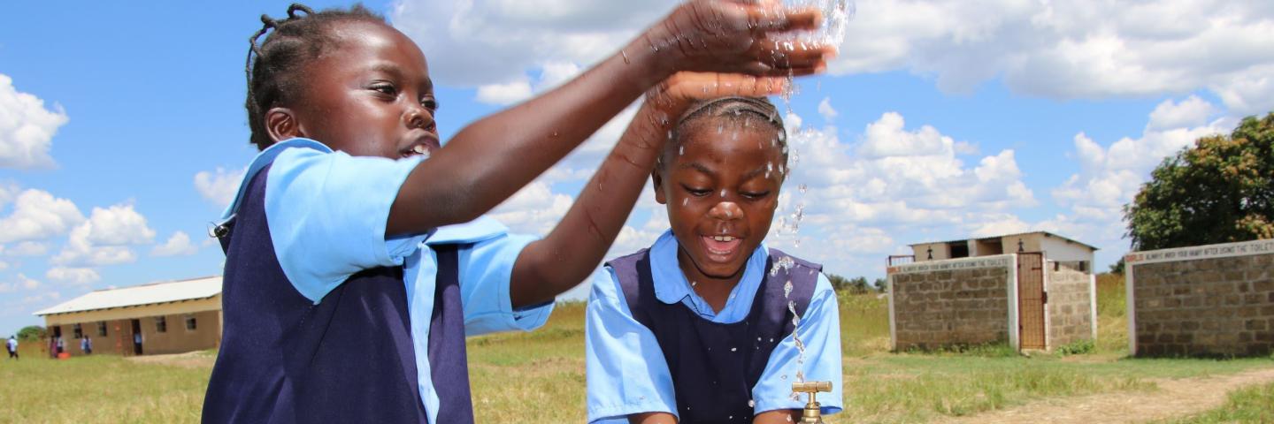 Girls play with water tap