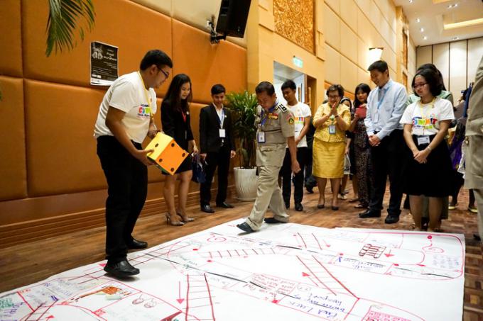 Wanchana (left) explaining to GMS senior officials about the Thai youths’ safe migration game at the COMMIT-SOM and IMM