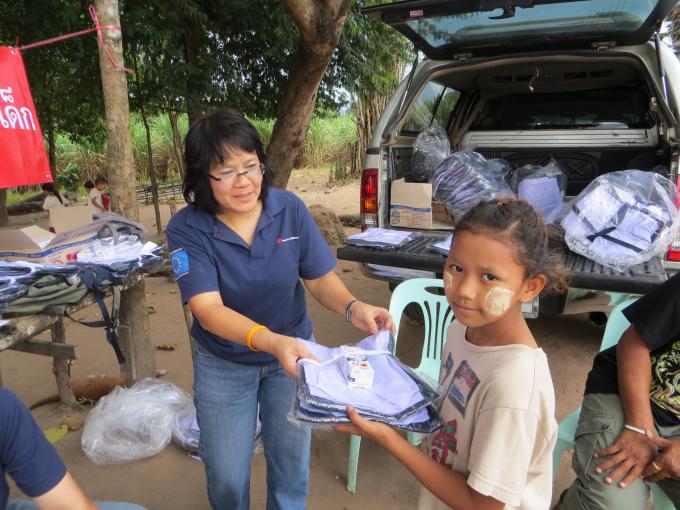 Su Myat San, whose family was affected by the floods in Mae Sot, receives school uniforms from Save the Children’s Emergency Response Team]